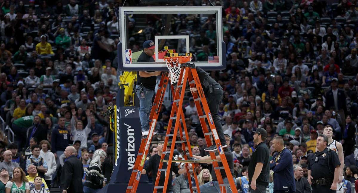 Los operarios de los Denver Nuggets intentan arreglar el aro destrozado en el Ball Arena de Denver./AFP