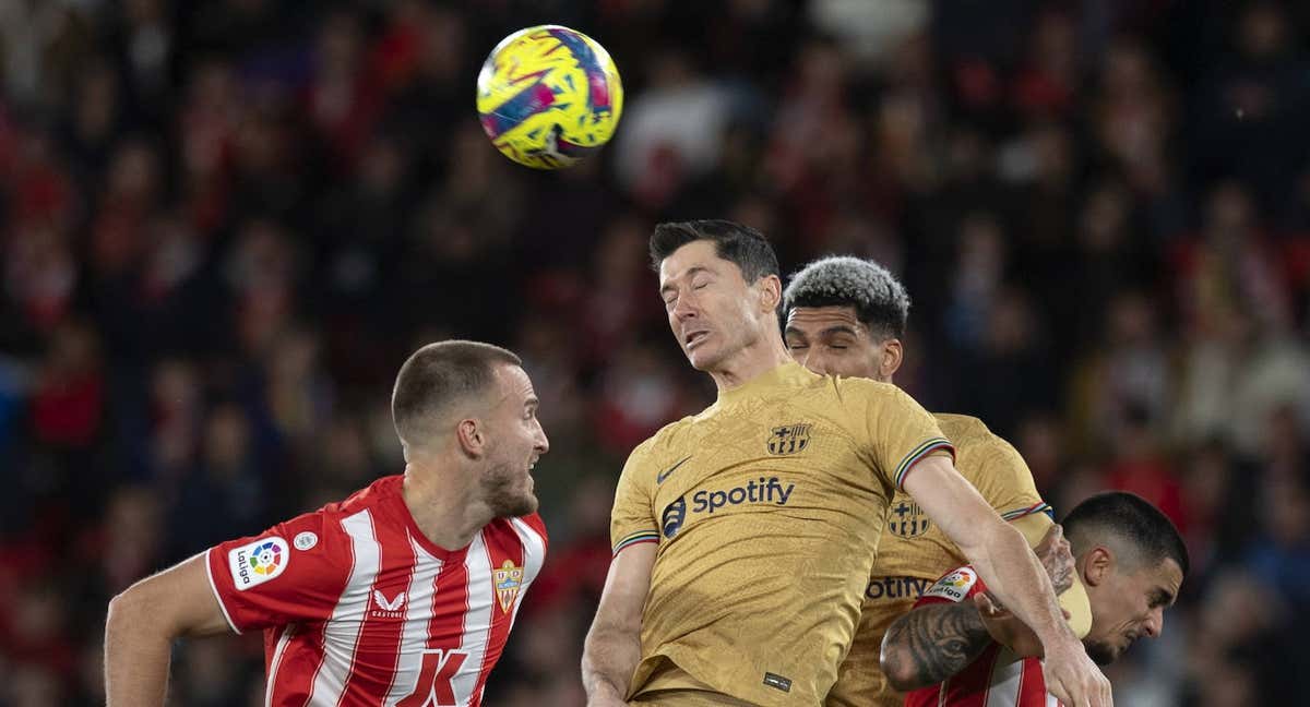 Lewandowski y Araujo saltan a por un balón en Almería./AFP