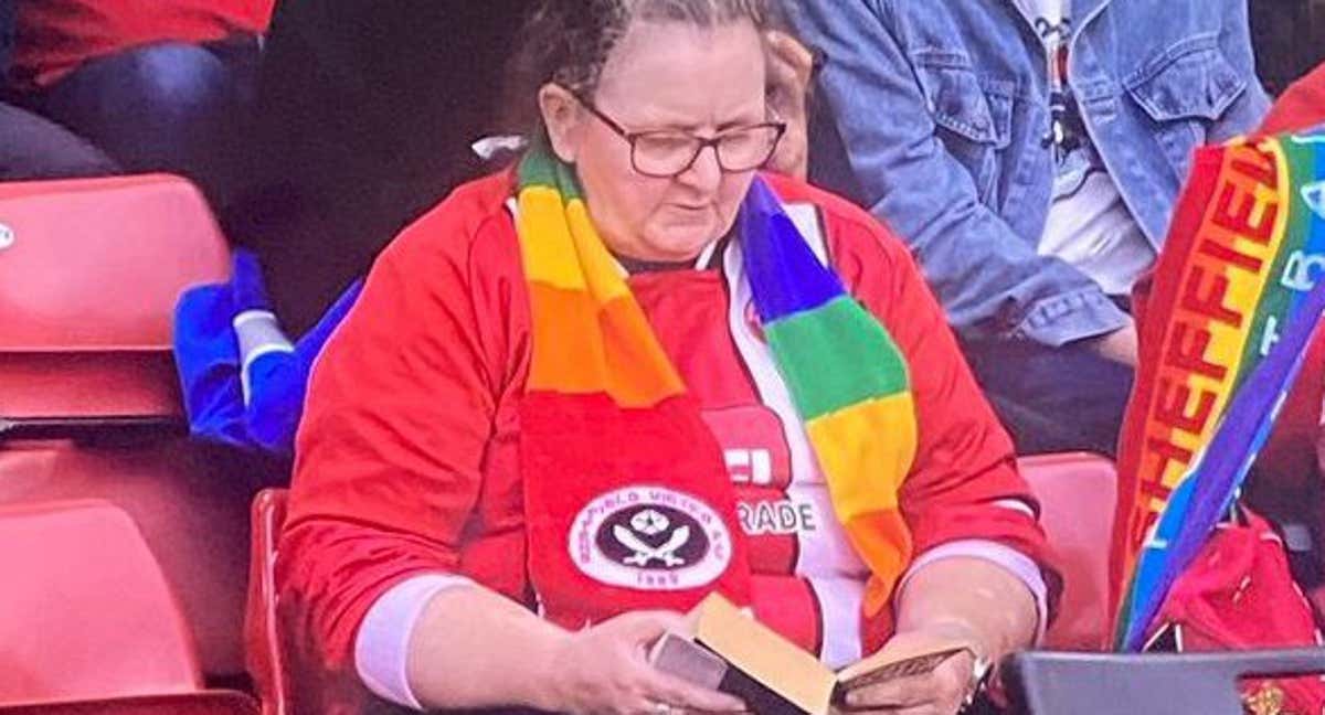 Una aficionada lee un libro en la goleada del Newcastle./