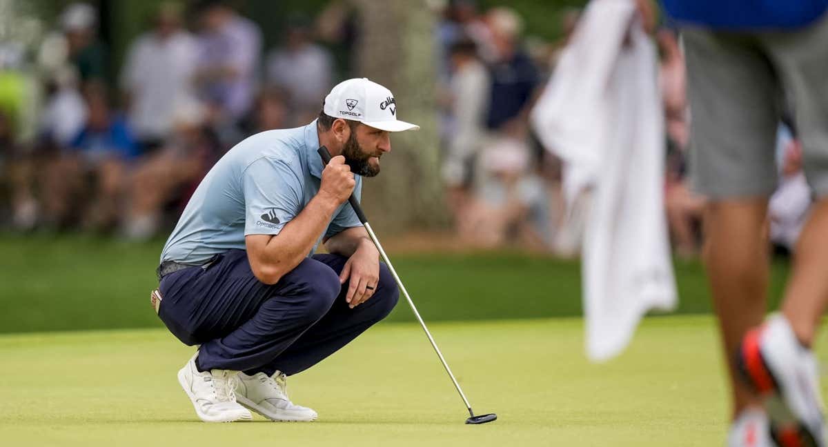Jon Rahm, de cuclillas en el green del hoyo nueve. /Reuters