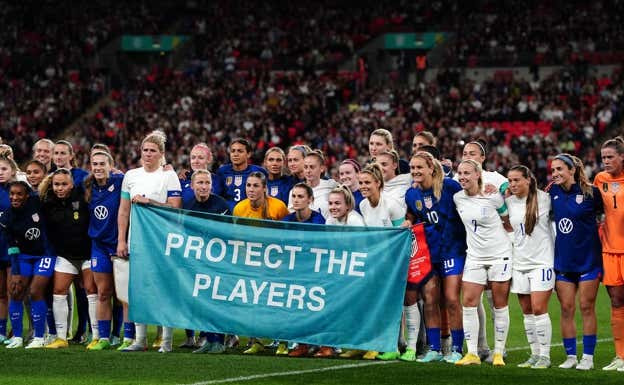 Las jugadoras de Estados Unidos e Inglaterra posan con el lema «Protect the Players».  Getty