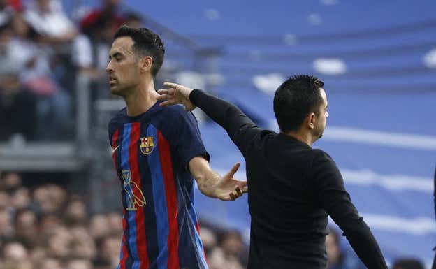 Busquets se saluda con Xavi en el momento de su sustitución en el Clásico REUTERS