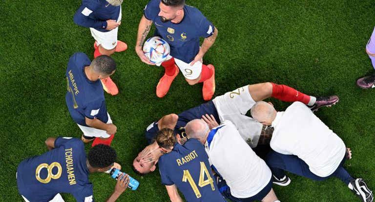 Jugadores y médicos de la selección francesa rodean a Lucas Hernández tras lesionarse.