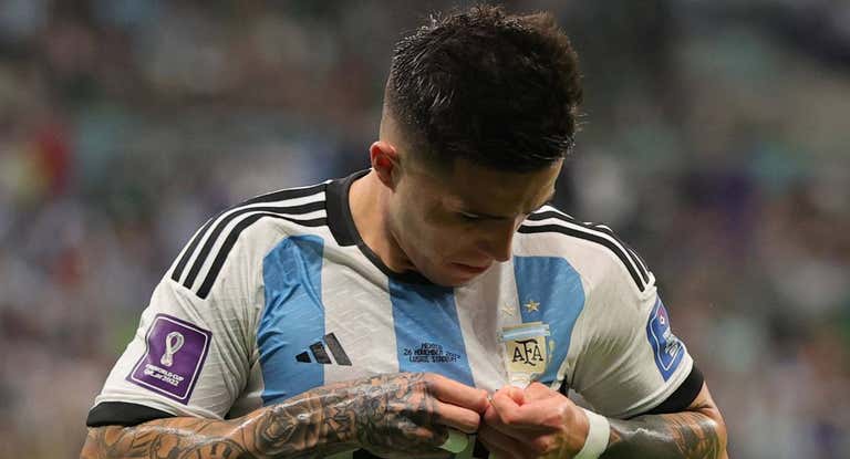 Enzo Fernández se mira el escudo de Argentina durante un partido del Mundial.