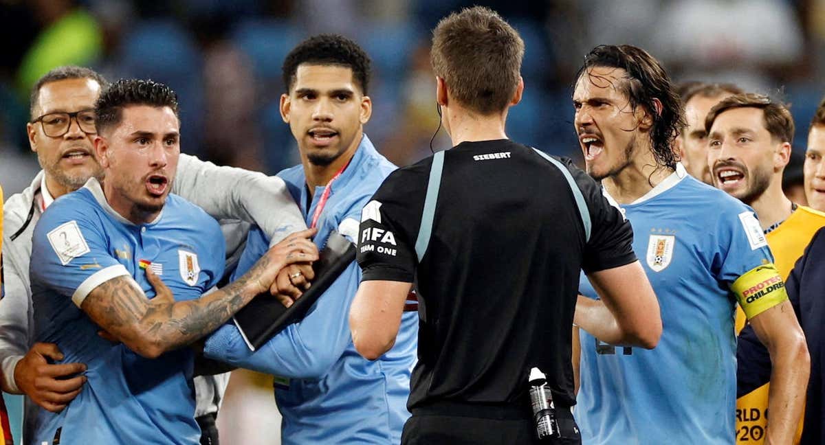 Los jugadores de Uruguay, entre ellos Giménez, rodean a Daniel Siebert tras el partido contra Ghana.