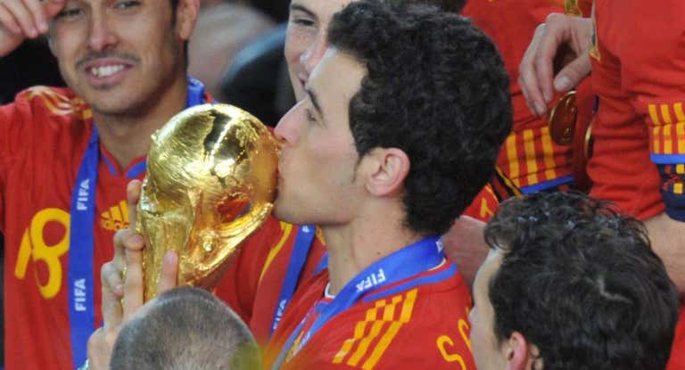Sergio Busquets, rodeado de compañeros, besa la Copa del Mundo en 2010.