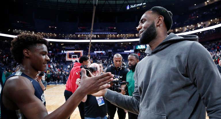 LeBron James felicita a su hijo mayor Bronny tras un partido.