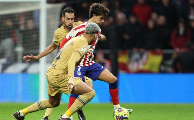 Acorralado Joao Félix, en una jugada de la primera mitad con Araujo y Busquets.  EFE