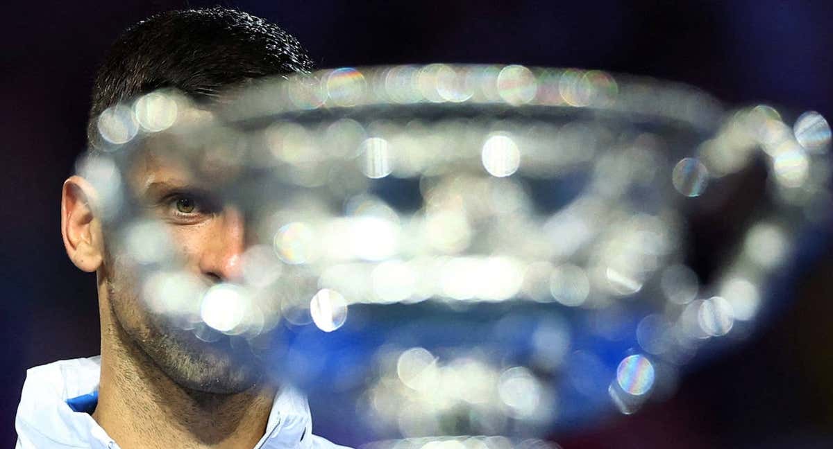 Novak Djokovic mira la copa del Open de Australia 2023.