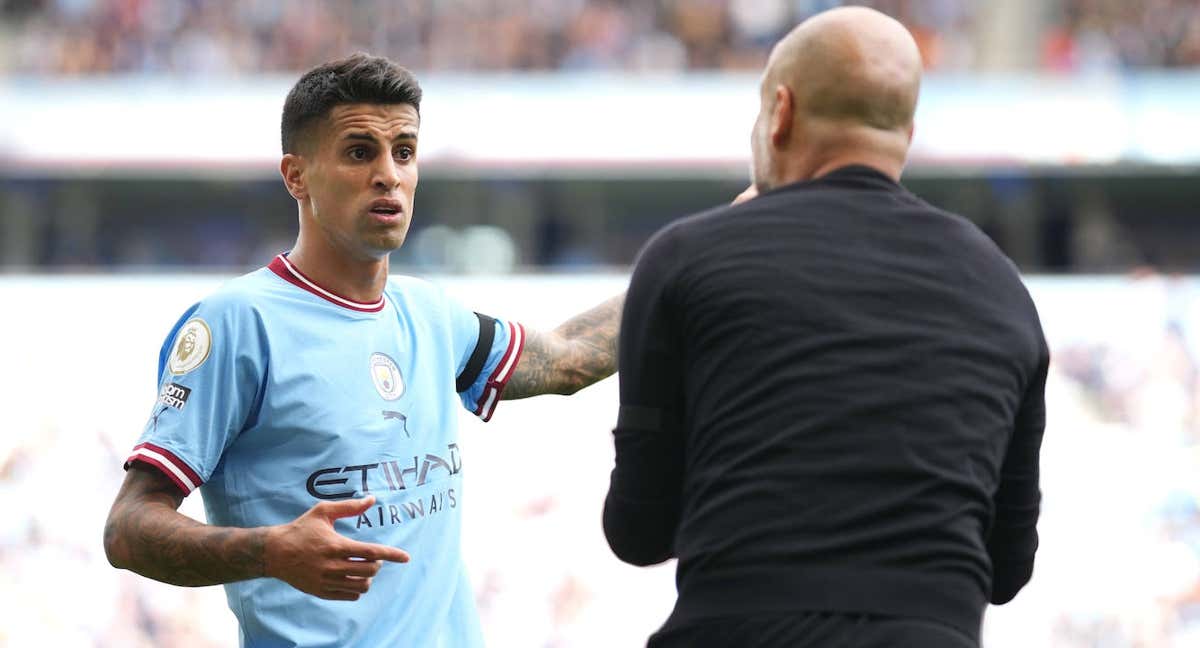 Joao Cancelo y Pep Guardiola./Getty Images