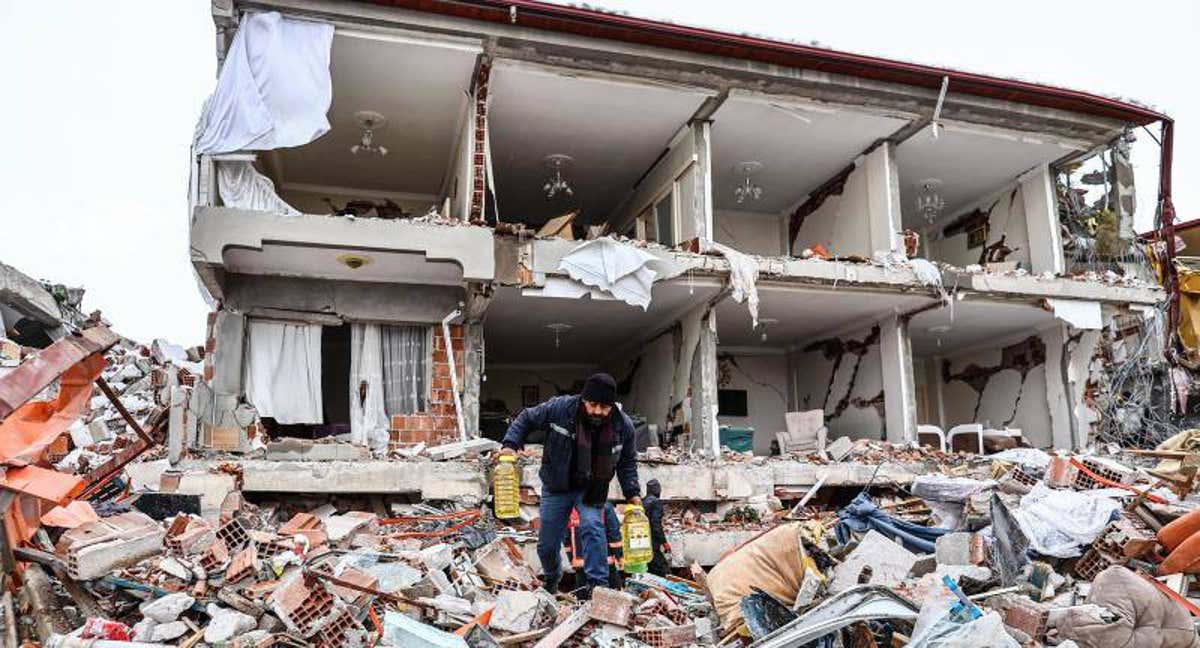Una persona busca entre los escombros de un edificio derrumbado por el terremoto en Turquía.
