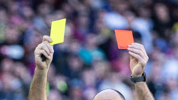 Un árbitro mostrando tarjeta durante un partido en el Camp Nou./EP