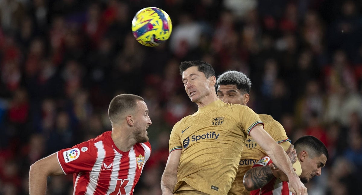 Lewandowski y Araujo saltan a por un balón en Almería.