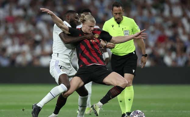 Rüdiger agarra a Haaland.  AFP