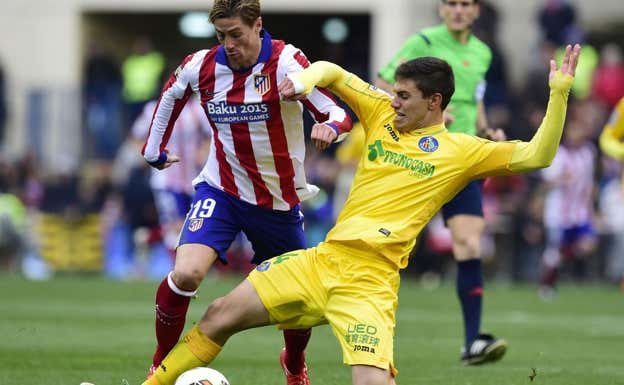 Emiliano Velázquez pugna con Fernando Torres por un balón en un Atlético de Madrid-Getafe. AFP