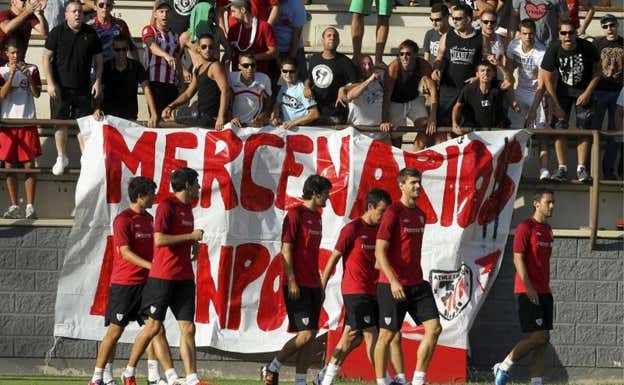 Pancarta de aficionados en un entrenamiento del Athletic, con el mensaje 'Merceranarios fuera' en referencia a Fernando Llorente y Javi Martínez.  EFE