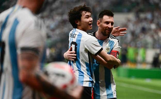 El aficionado abraza a Messi.  AFP