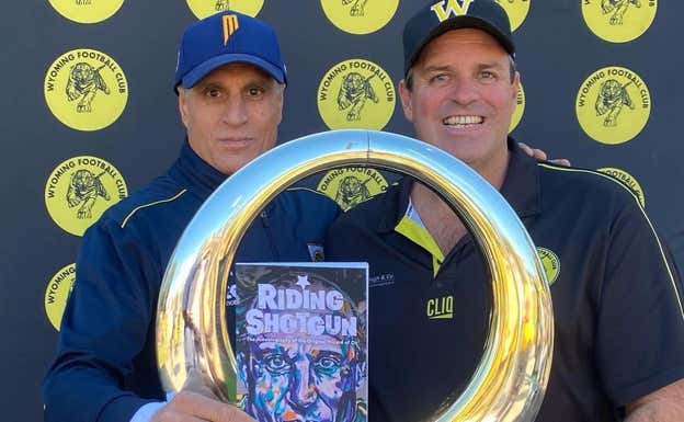 Andy Bernal, a la izquierda, posa con el trofeo de campeón de la liga y con su libro. INSTAGRAM