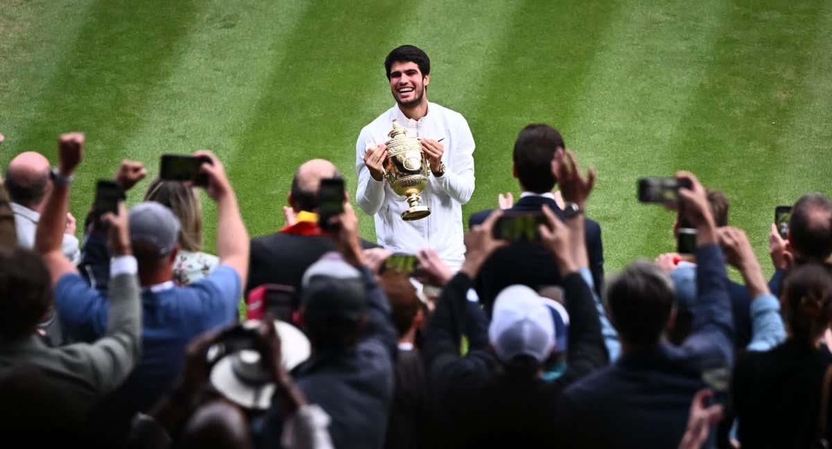 Carlos Alcaraz posa con la copa de campeón en la pista central de Wimbledon.