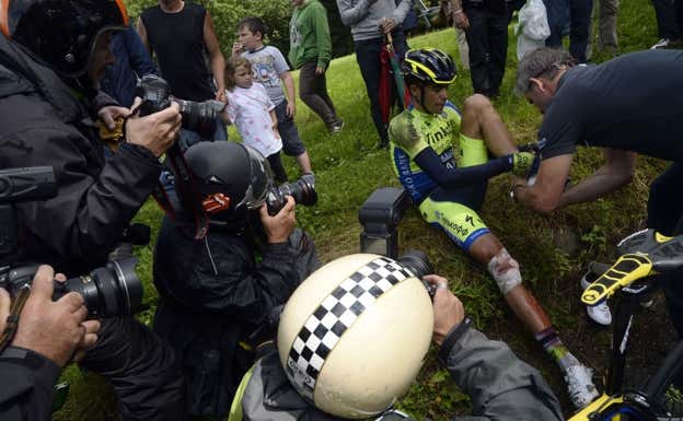 Alberto Contador, rodeado de fotógrafos tras la caída. AFP