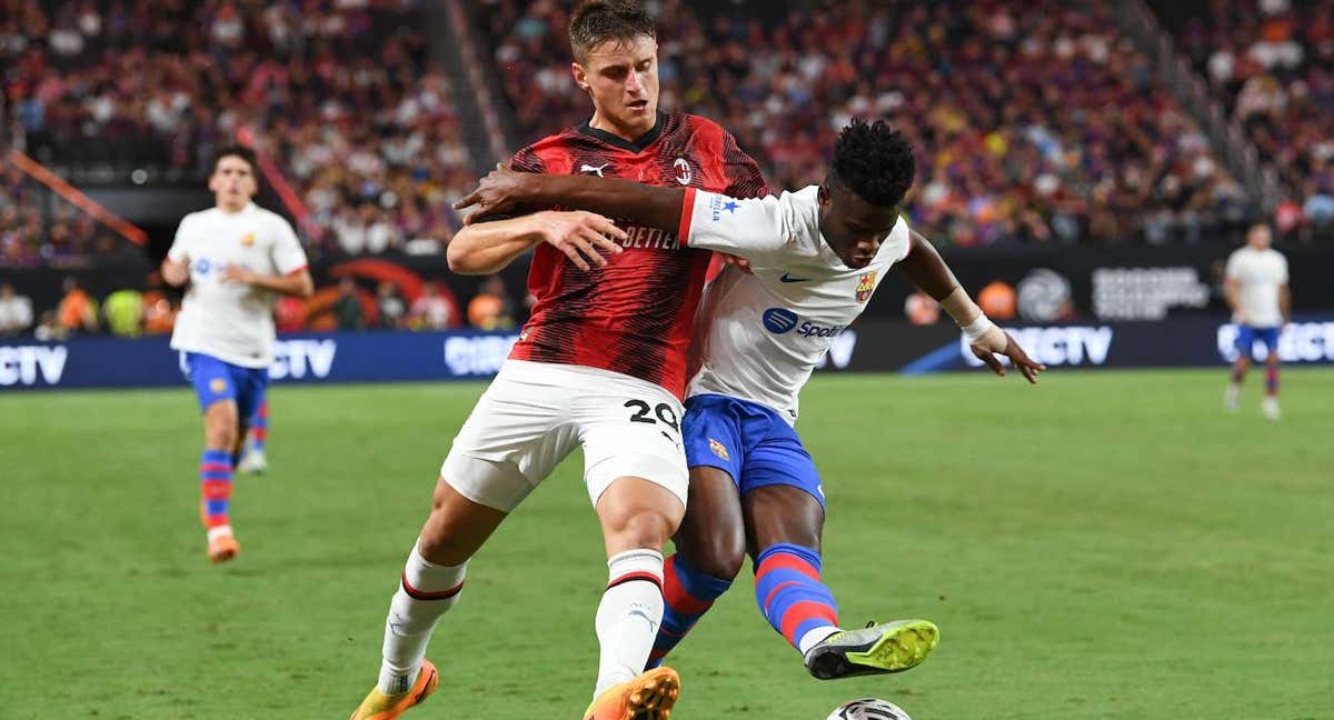 Faye 'cuerpea' con un delantero del Milan para controlar el balón./AGENCIAS