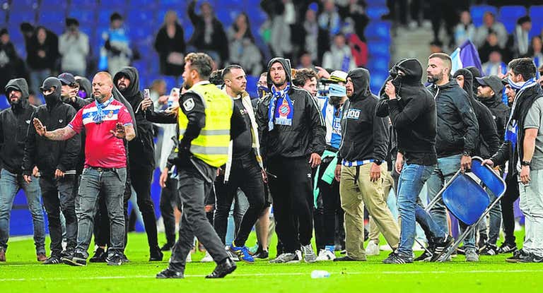 Aficionados del Espanyol invaden el terreno de juego tras la celebración del FC Barcelona.