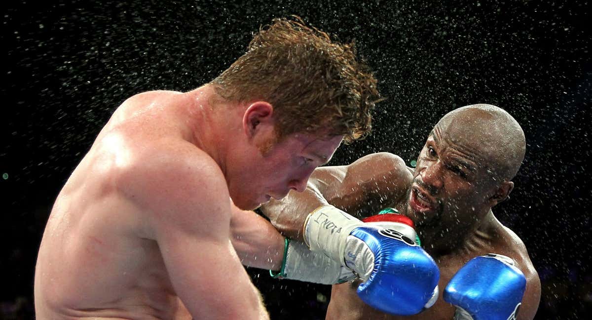 Canelo Álvarez y Floyd Mayweather intercambian golpes durante su combate./AFP