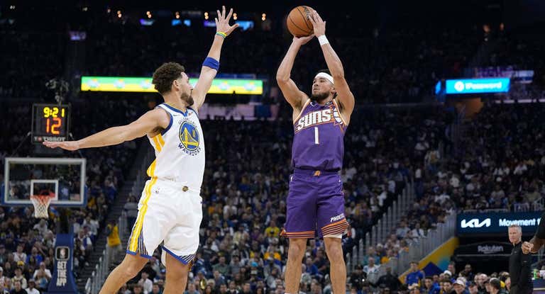 Devin Booker lanza ante la defensa de Klay Thompson.