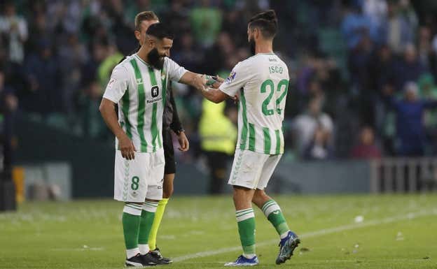 Isco le coloca el brazalete a Fekir cuando éste salta al césped. EFE