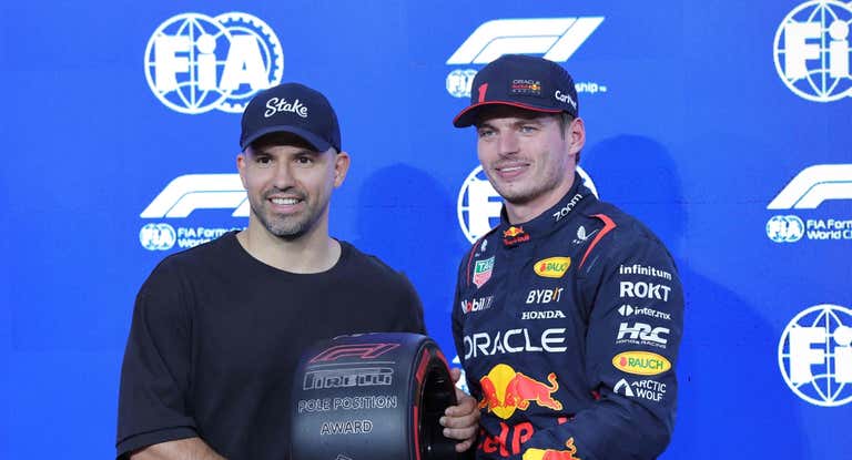 Sergio Agüero entregando la rueda por la pole a Max Verstappen.