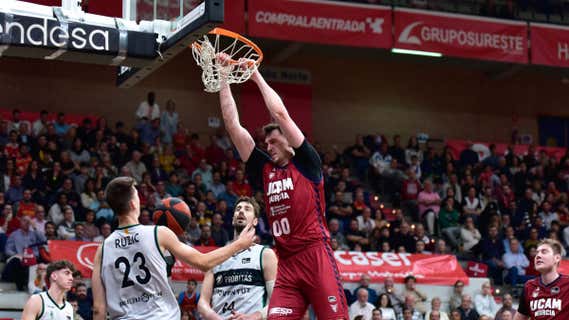 Rodions Kurucs se cuelga del aro en el partido ante la Penya. /ACB PHOTO/J. BERNAL
