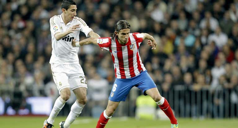 Di María pelea un balón con Filipe Luis en un derbi madrileño del año 2011.