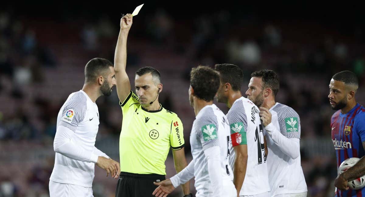 Jaime Latre amonesta a un jugador del Granada en un enfrentamiento contra el Barça.