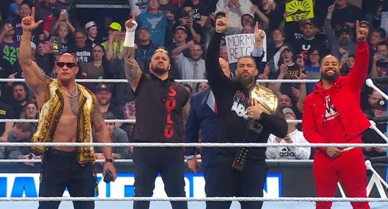 The Rock, Solo Sikoa, Paul Heyman, Roman Reings y Jimmy Uso posan para el público en SmackDown.