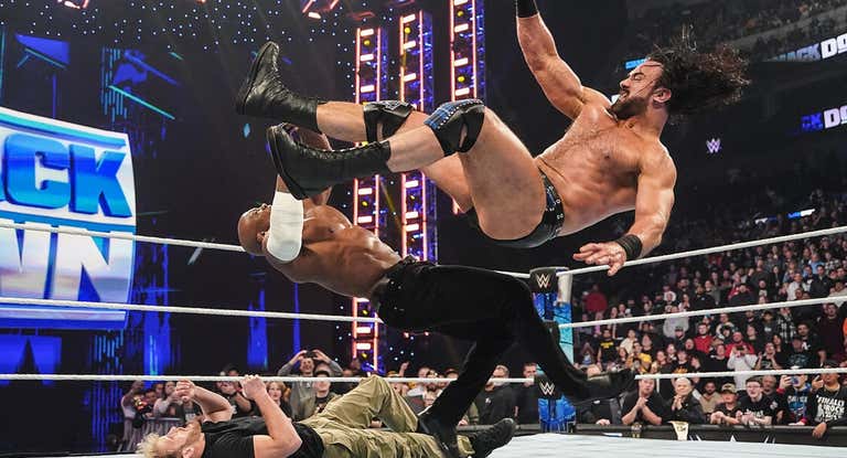 Drew McIntyre golpea a Bobby Lashley mientras Logan Paul está en el suelo.