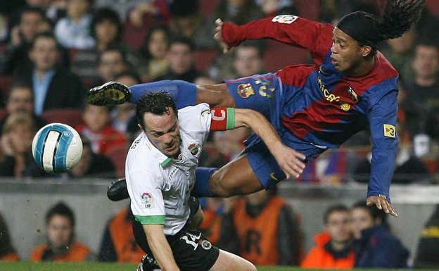 Ronaldinho y Pinillos durante un Barça-Racing. AGENCIAS