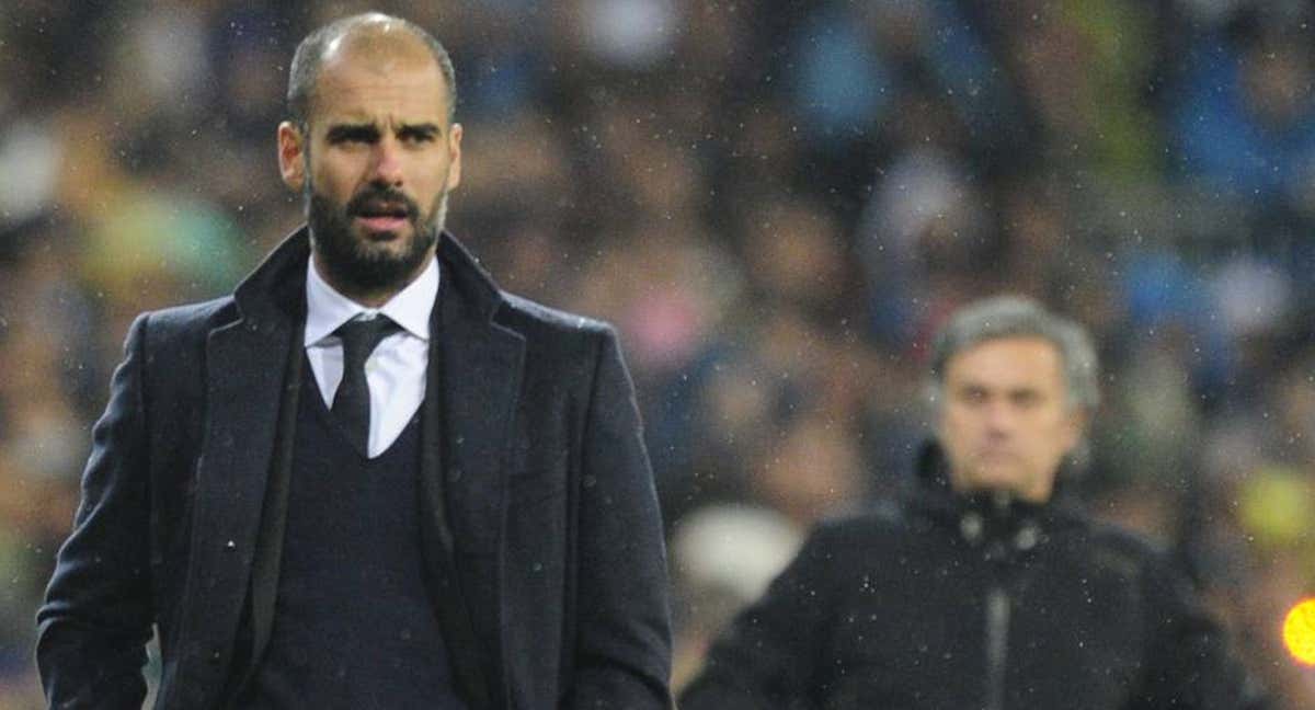 Guardiola, con Mourinho de fondo, en un Clásico disputado en el Bernabéu en 2011. /AFP