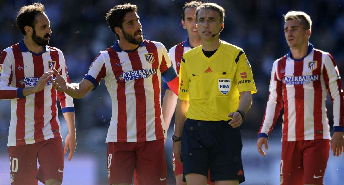 Raúl García reclama a Fernández Borbalán durante un partido en su etapa en el Atlético./AFP