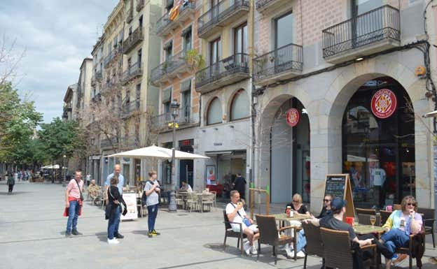 Turistas enfrente de la tienda del Girona en La Rambla de la Llibertat.  RELEVO