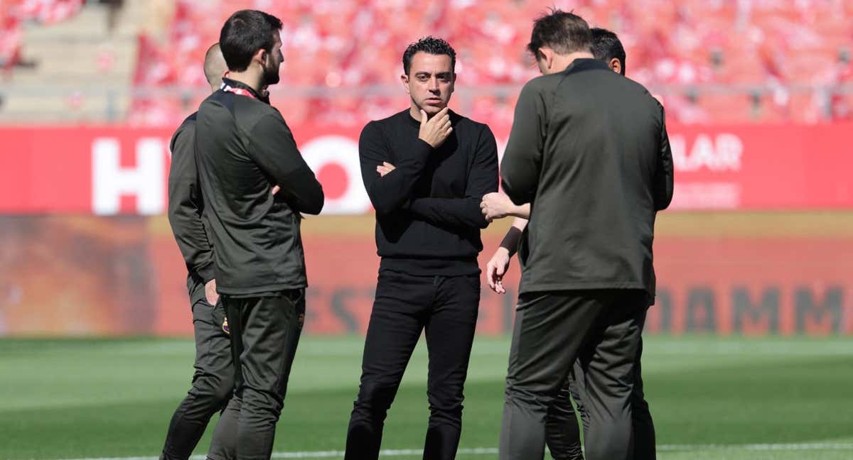 Xavi Hernández, en el centro del campo de Montilivi con su cuerpo técnico. /AFP