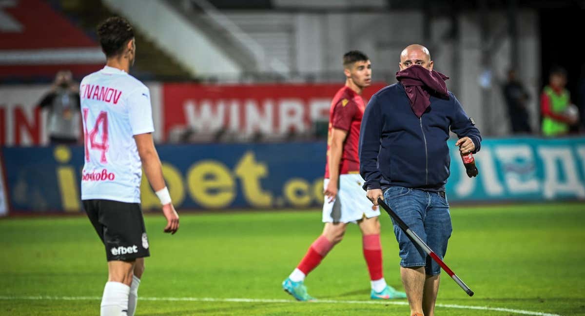 Un ultra del CSKA, en el césped del Levski, amenaza a los jugadores con un bate.  /GETTY