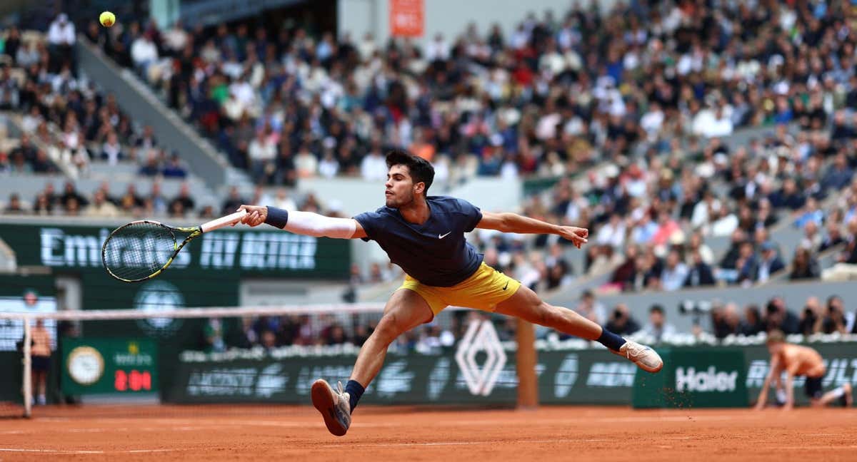 Carlos Alcaraz trata de llegar a una pelota durante su partido ante Auger-Aliassime en Roland Garros. /AFP