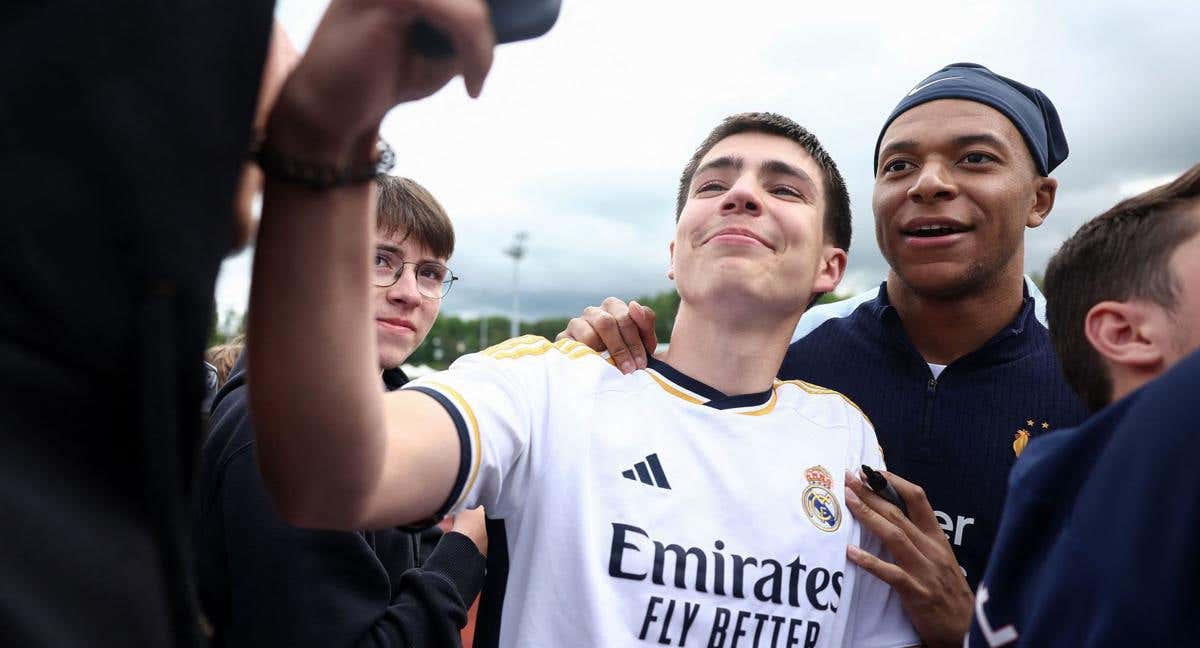 Mbappé posa con un aficionado del Real Madrid. /AFP