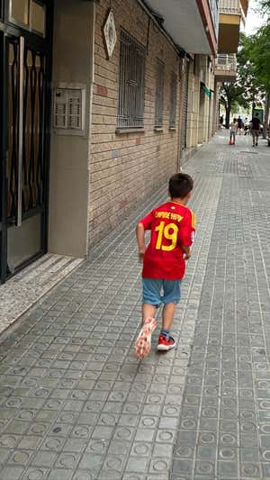Un niño con la camiseta de Lamine corre por el barrio. RELEVO