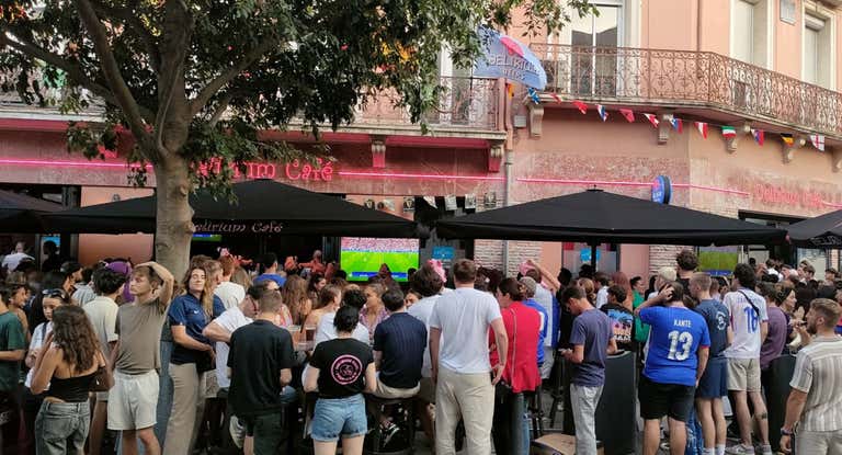 Varias personas se aglomeran en Perpignan en torno a la televisió para ver el Francia-España de este martes.
