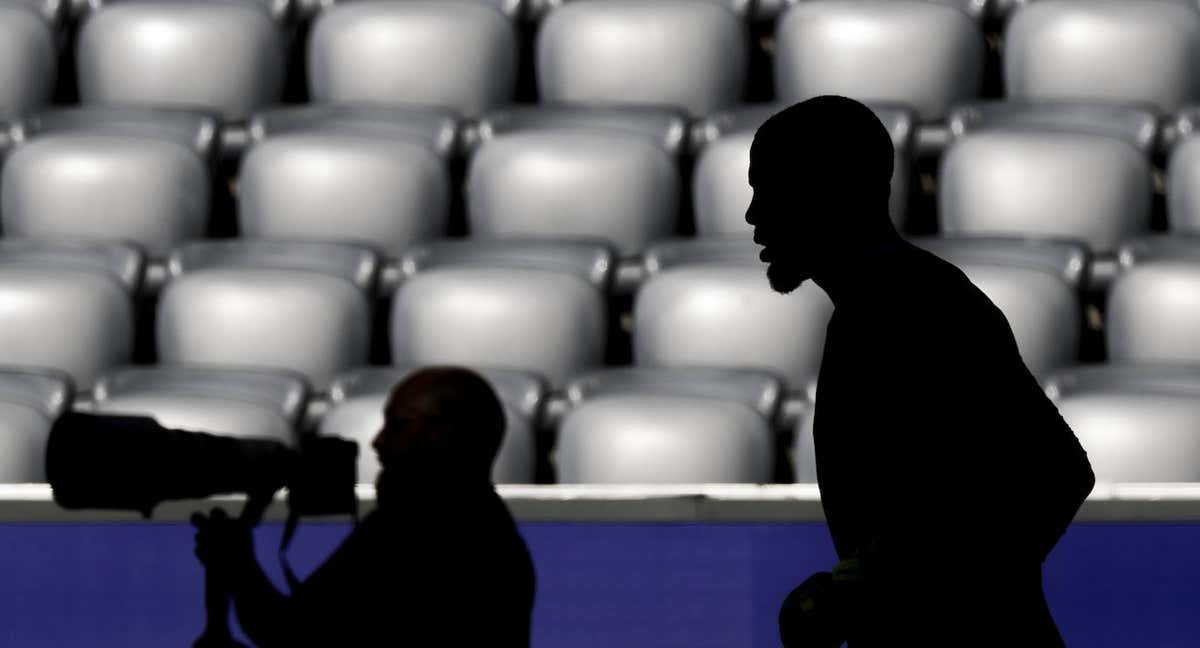 La silueta de un fotógrafo y un deportista durante un evento deportivo. /Getty