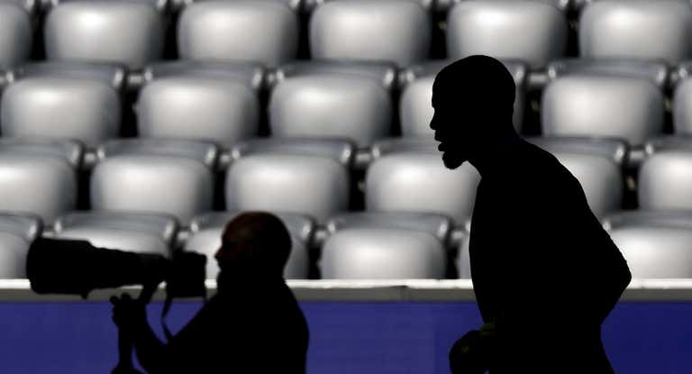 La silueta de un fotógrafo y un deportista durante un evento deportivo.