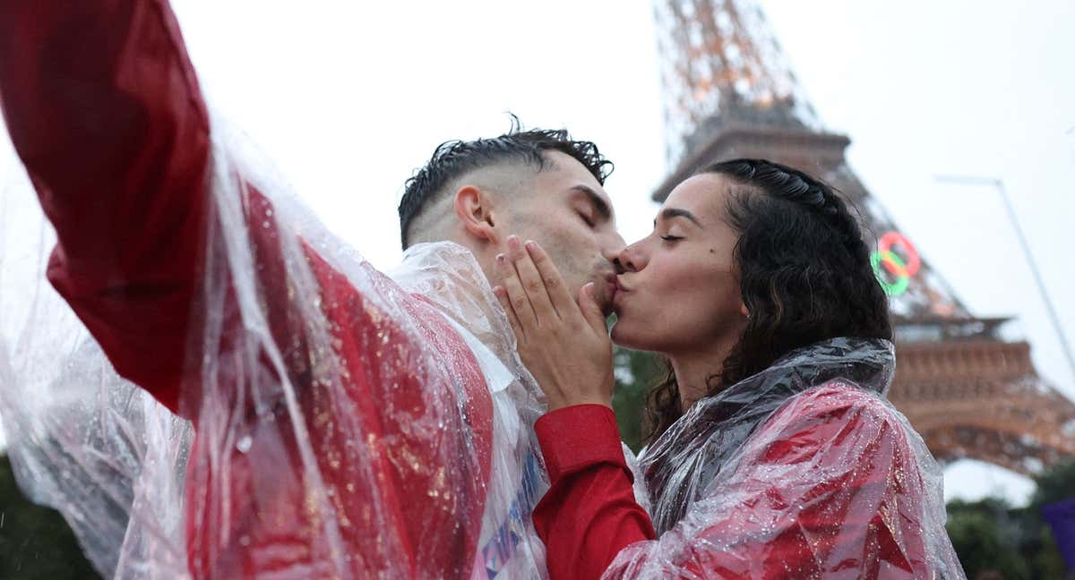 David Vega y Noemí Romero se besan delante de la Torre Eiffel tras el desfile inaugural./GETTY