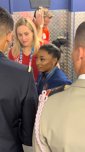 Biles atiende a varios militares franceses que le piden una foto.