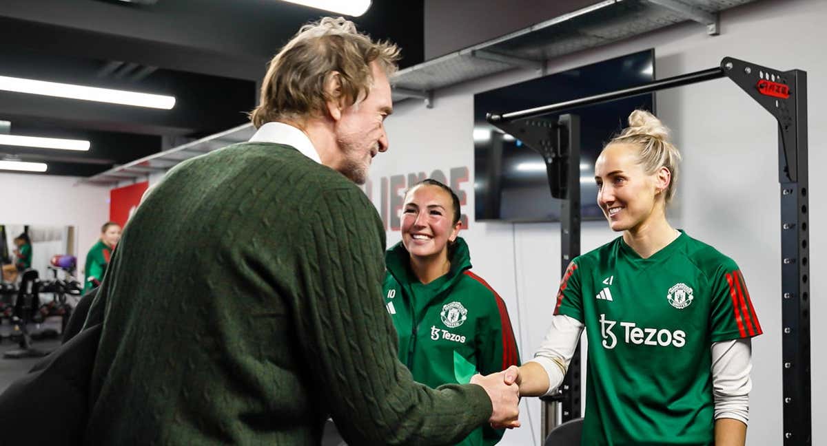 Jim Ratcliffe saludando a Kaite Zelem y Millie Turner durante una sesión del equipo femenino en el gimnasio.